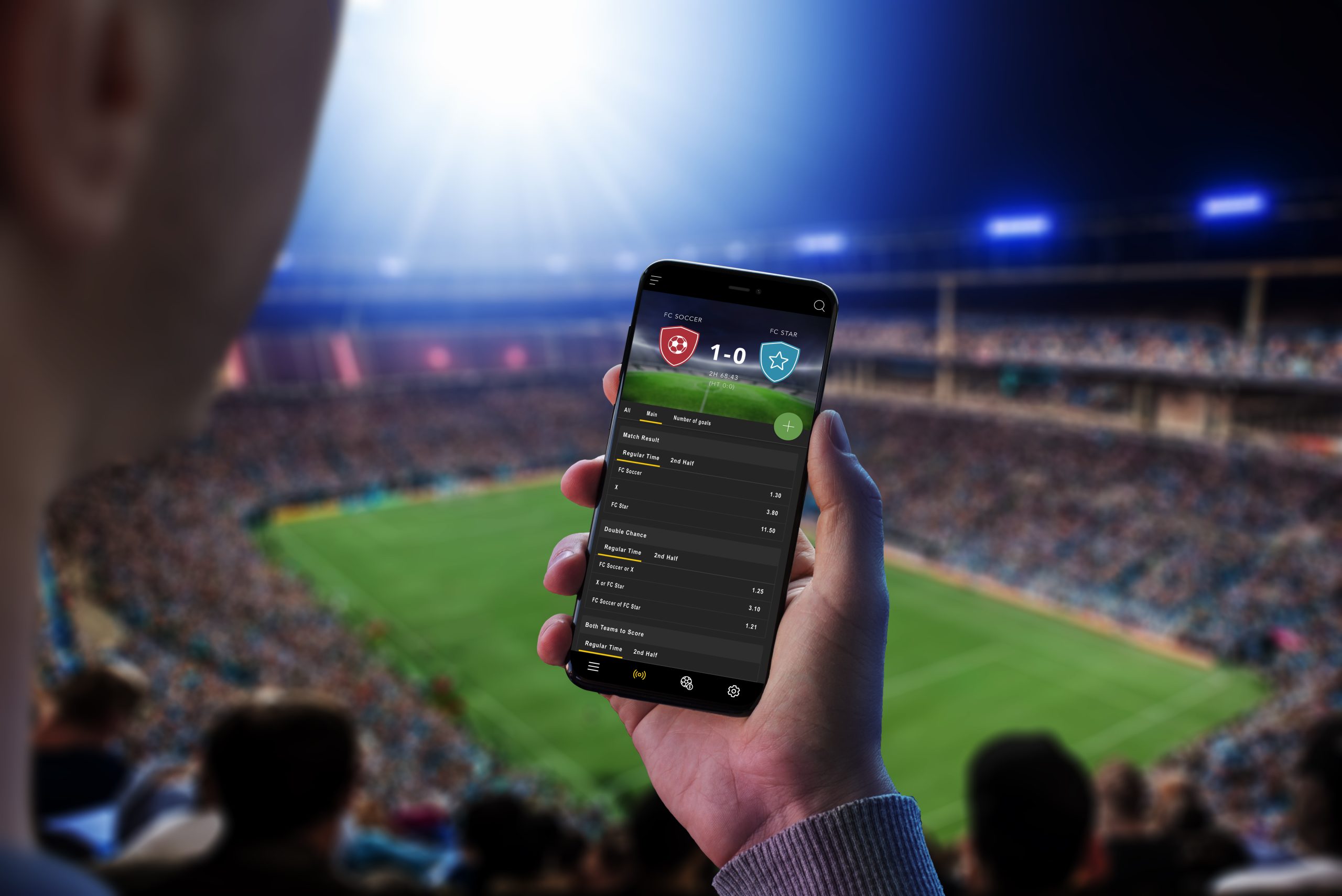 Man at a football match follows the odds and the current score. The concept of online sports betting. Football stadium and crowd in the background